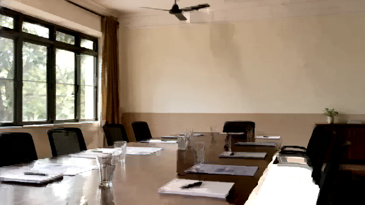 Empty school meeting room prepared for a vendor evaluation, printed documents and water glasses at each seat.